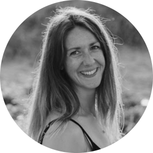 A woman with long hair smiling at the camera (Krissie), our Founder and CEO in black and white